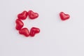 Concept of a lonely heart made of heart shaped red jelly sweets on white background. Top view. Copy space.