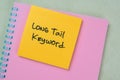 Concept of Long Tail Keyword write on sticky notes isolated on Wooden Table Royalty Free Stock Photo