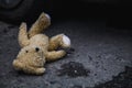 Concept: lost childhood, loneliness, pain and depression. Teddy bear lying down outdoors