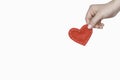 Concept of love, heart treatment. A woman`s hand holds a red fabric heart. White background, isolated