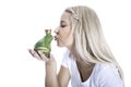 Concept for love: isolated blonde woman is kissing a frog in her Royalty Free Stock Photo