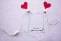 concept love music lovers earphones with red hearts coming out with a picture frame with words be my valentine flat lay on white Royalty Free Stock Photo