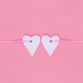 Concept of love. Two hearts side by side on pink ribbon on pastel pink color background