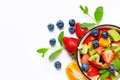 Concept of low calories delicious dessert. Summer fresh bowl with colorful fruit salad. Healthy natural organic food. White Royalty Free Stock Photo