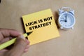 Concept of luck is not strategy write on sticky notes isolated on Wooden Table Royalty Free Stock Photo