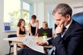 The concept of making business solution. Serious businessman reading a contract sitting in the chair in the office on Royalty Free Stock Photo