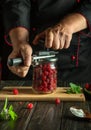 The concept of making raspberry jam on the kitchen table by the hands of the cook. Preserved raspberries for long-term storage Royalty Free Stock Photo
