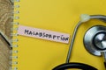 Concept of Malabsorption write on sticky notes with stethoscope isolated on Wooden Table