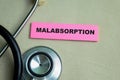 Concept of Malabsorption write on sticky notes with stethoscope isolated on Wooden Table