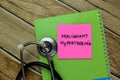 Concept of Malignant Hyperthermia write on sticky notes with stethoscope isolated on Wooden Table