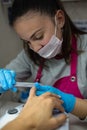 Concept: manicure. Manicurist working. young girl doing nail work on adult woman hands. Filing nails in beauty salon Royalty Free Stock Photo