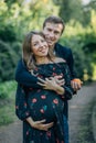 Concept married couple is pregnant. Portrait of woman, future mother and man father, hugging stroking big belly, vertical shot