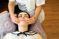 The concept of medicine and cosmetology. Young woman at a session of acupuncture facial massage, close-up. Top view