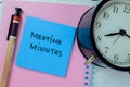 Concept of Meeting Minutes write on sticky notes isolated on Wooden Table Royalty Free Stock Photo