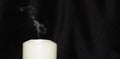 The concept of the memorial. An extinguished candle with smoke on a black background, free space for text Royalty Free Stock Photo