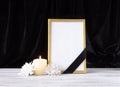 The concept of memory, funerals and condolences. Photo frame with black mourning ribbon, candle and flowers Royalty Free Stock Photo