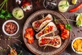 The concept of Mexican cuisine. Mexican food and snacks on a wooden table. Taco, sorbet, tartar, glass and bottle of red wine. Royalty Free Stock Photo