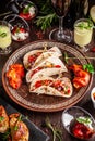 The concept of Mexican cuisine. Mexican food and snacks on a wooden table. Taco, sorbet, tartar, glass and bottle of red wine. Royalty Free Stock Photo