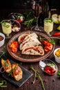 The concept of Mexican cuisine. Mexican food and snacks on a wooden table. Taco, sorbet, tartar, glass and bottle of red wine. Royalty Free Stock Photo