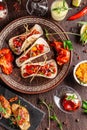 The concept of Mexican cuisine. Mexican food and snacks on a wooden table. Taco, sorbet, tartar, glass and bottle of red wine. Royalty Free Stock Photo