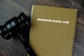 Concept of Minimum Wage Law write on a book with gavel isolated on Wooden Table Royalty Free Stock Photo
