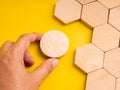 Concept of mismatch and problem solving with hand holding a round wooden piece not fitting into hexagon space. Symbolizes Royalty Free Stock Photo
