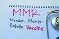 Concept of MMR - Measles Mumps Rubella Vaccine write on book with stethoscope isolated on white background Royalty Free Stock Photo