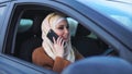 Concept of modern hijab. Muslim woman drives a right-hand drive car