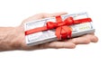 Concept, money as gift, win or bonus. Man`s hand takes or gives pile of 100 dollar bills tied with red ribbon with bow. Isolated Royalty Free Stock Photo