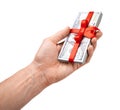 Concept, money as gift, win or bonus. Man`s hand takes or gives pile of 100 dollar bills tied with red ribbon with bow. Isolated Royalty Free Stock Photo