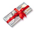 Concept, money as gift, win or bonus. Pile of 100 dollar bills is tied with red ribbon with bow. Isolated on white Royalty Free Stock Photo