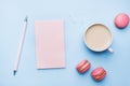 Concept morning Breakfast. Cup of coffee, macaroon cookies and notepad on blue pastel background. Flat lay style Royalty Free Stock Photo