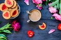 The concept of morning coffee in a romantic style on the black wooden background. Peonies flowers and petals, cookies, heart candl Royalty Free Stock Photo