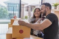 The concept of moving house. Closeup of Couple packing cardboard boxes to move to a new home