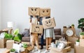 Concept of moving to a new apartment and a mortgage.  funny family with boxes on their heads, on which smiley faces are painted Royalty Free Stock Photo