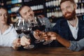 Concept Multicultural friendship, closeup hands of African woman and European men are checked with glasses of red wine