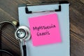 Concept of Myasthenia Gravis write on sticky notes with stethoscope isolated on Wooden Table Royalty Free Stock Photo