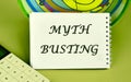 Concept MYTH BUSTING word, text a note written on a blank sheet of a notebook in a composition with a fragment of a calculator, an