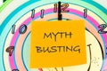 Concept MYTH BUSTING word, text on a yellow sticker on the background of a clock face with hands