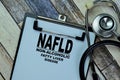 Concept of NAFLD - Non-Alcoholic Fatty Liver Disease write on paperwork with stethoscope isolated on Wooden Table Royalty Free Stock Photo