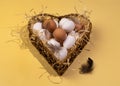 Concept for National Egg Month. White and brown eggs lie on shavings in a heart-shaped basket. Royalty Free Stock Photo