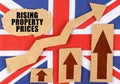 On the flag of Great Britain, a growth chart and a cardboard plate with the inscription - Rising property prices Royalty Free Stock Photo