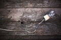 Concept - Neglect Of Fire Safety. Retro Incandescent Lamp With Damaged Wires And Isolation By Electrical Tape, On Vintage Wooden B