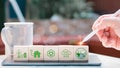 Concept of net zero and carbon neutrality. Hand places wooden cubes with the netzero icons for waste recycling, green production, Royalty Free Stock Photo