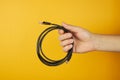 Concept of network, internet, communications. hand holds cat 5e utp cable. Isolated on yellow background Royalty Free Stock Photo