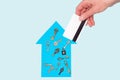 Female hand holds a credit card over a blue model paper house and keys on a pastel background, mock up Royalty Free Stock Photo