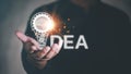 Concept of New idea creativity and inspiration.Light bulb with gears and brain inside and illuminating In the hands of business pe Royalty Free Stock Photo