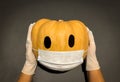 Concept of new normal Halloween showing pumpkin wearing mask for corona virus protection