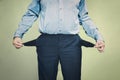 concept no money. businessman standing on the green background and showing his empty pocket, turning his pocket inside Royalty Free Stock Photo