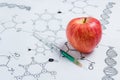 Concept of Non-natural Products, Gmo. Syringe and Red Apple on White Background with Chemical Formula, Royalty Free Stock Photo